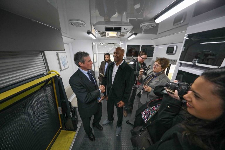 Tyrone Mathis (right) and Del. Gov. John Carney (left) shake hands after touring 