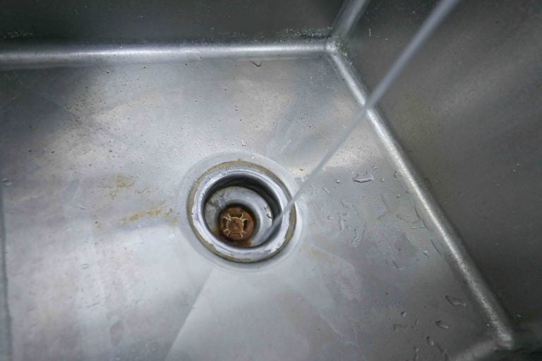 Dora Bell-Isler runs tap water to demonstrate the horrible smell coming from the faucet Monday, Sept.16, 2019, in Frankford, Del. (Saquan Stimpson for WHYY)