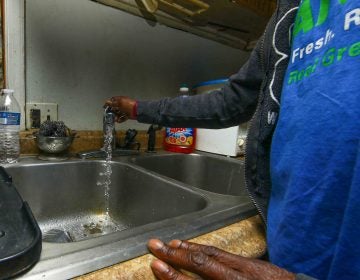 Angialeen Mullen runs tap water to demonstrate the horrible smell coming from the faucet Tuesday, Oct. 08, 2019, in Ellendale, Del. (Saquan Stimpson for WHYY) 