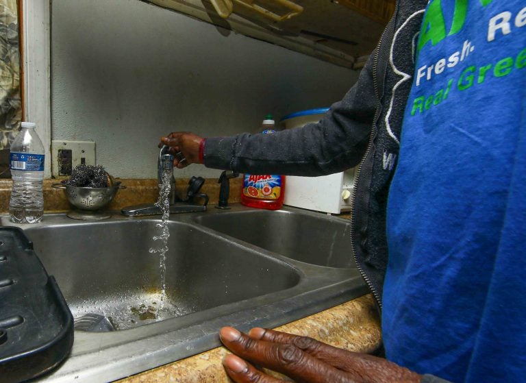 Angialeen Mullen runs tap water to demonstrate the horrible smell coming from the faucet Tuesday, Oct. 08, 2019, in Ellendale, Del. (Saquan Stimpson for WHYY) 