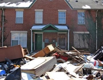 Garbage is piled in front of an apartment complex in Lower Germantown. (Emma Lee/WHYY)