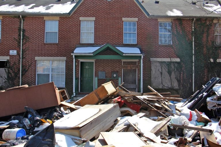 Garbage is piled in front of an apartment complex in Lower Germantown. (Emma Lee/WHYY)