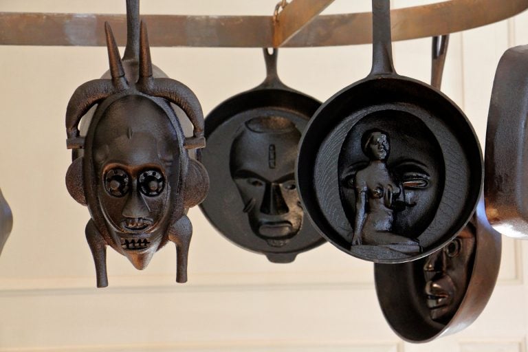 Cast iron skillets hanging in the kitchen at Bainbridge House are from Hugh Hayden's series, 'American Food.' They are modeled from African Masks and historical artifacts in the Princeton University Art Museum collections. (Emma Lee/WHYY)