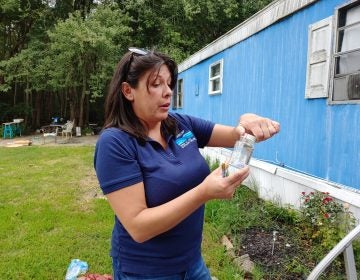 Consuelo McGowan from SERCAP collects samples for testing at a mobile home in Ellendale, Del. McGowan works for a non-profit that provides kits for testing well water. (Zoe Read/WHYY)