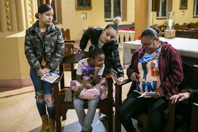 Friends and family of Sincere Howard remember his life by showing pictures at Parish of the Cathedral during a vigil in Camden, NJ on Monday, December 30, 2019. The 22 hours Vigil was held to commemorate the 24 murders in Camden City in the year 2019. (Miguel Martinez for WHYY).