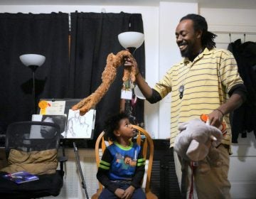 Single parent Deshaun Sherrill and his son Zay’ion Ventura-Sherrill clean up the living room of their home in West Philadelphia. (Bastiaan Slabbers for WHYY)
