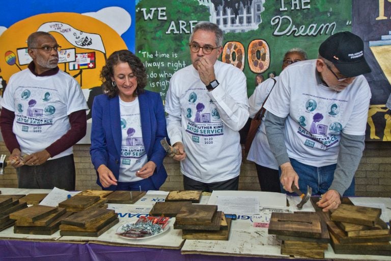 Philadelphia District Attorney Larry Krasner (center right) wields a hammer at the MLK Day of Service at Philadelphia’s Girard College. (Kimberly Paynter/WHYY)