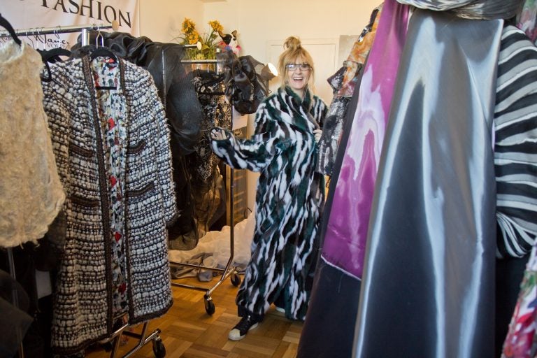 Nancy Volpe-Beringer wraps herself in an Eagles' inspired faux fur coat in her studio. (Kimberly Paynter/WHYY)
