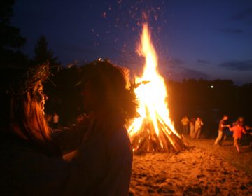 People dance around a campfire. (Vadim Rimakov/ AP Photo)