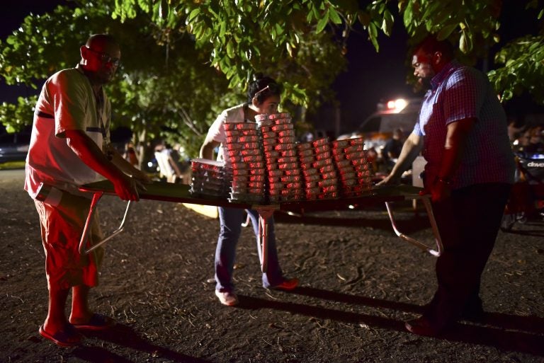 Volunteers move food for many refugees from Guanica that choose to remain outdoors for fear of possible aftershocks on their first night after a  6.4-magnitude earthquake struck Puerto Rico, killing one man, injuring at least eight other people and collapsing buildings, in Guanica, Puerto Rico, Tuesday, Jan. 7, 2020. (Carlos Giusti/AP Photo)