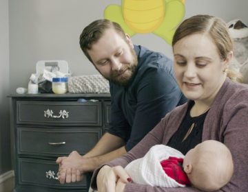 Jennifer and Drew Gobrecht look at their baby, Benjamin, at home in Ridley Park, Pa. Jennifer gave birth in November 2019 following a uterine transplant. (Penn Medicine via AP)