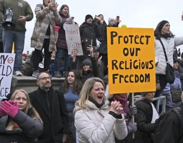 People hold signs during a protest at the state house in Trenton, N.J., Monday, Jan. 13, 2020. New Jersey lawmakers are set to vote Monday on legislation to eliminate most religious exemptions for vaccines for schoolchildren, as opponents crowd the statehouse grounds with flags and banners. (Seth Wenig/AP Photo)