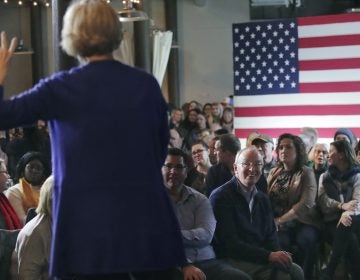 In this Jan. 10, 2020, file photo, Bruce Mann, husband of Democratic presidential candidate Sen. Elizabeth Warren, D-Mass., right, smiles as he listens to his wife during a campaign stop in Dover, N.H. (Charles Krupa/AP Photo)