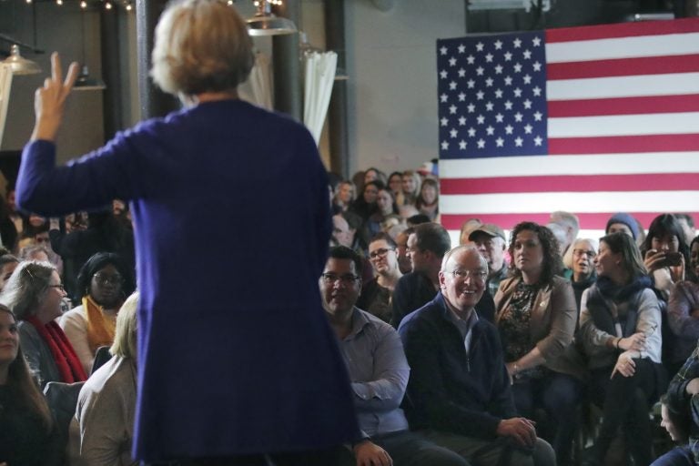 In this Jan. 10, 2020, file photo, Bruce Mann, husband of Democratic presidential candidate Sen. Elizabeth Warren, D-Mass., right, smiles as he listens to his wife during a campaign stop in Dover, N.H. (Charles Krupa/AP Photo)