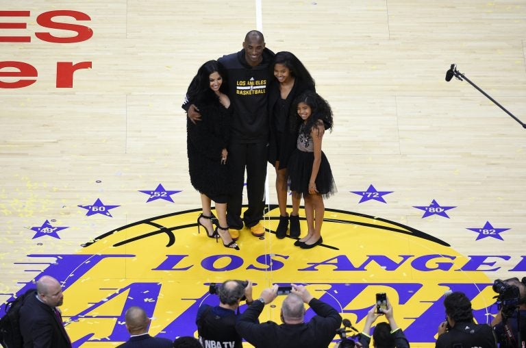In this April 13, 2016, file photo, Los Angeles Lakers' Kobe Bryant poses for pictures with his wife Vanessa, left, and daughters Natalia, second from right, and Gianna as they stand on the court after an NBA basketball game against the Utah Jazz, in Los Angeles. (Mark J. Terrill/AP Photo)