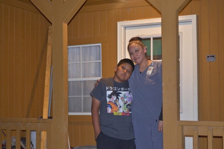 Chelsea and Ethan Holtsoi in front of their cabin near Many Farms on the Navajo Reservation. (Eilís O’Neill/For WHYY)