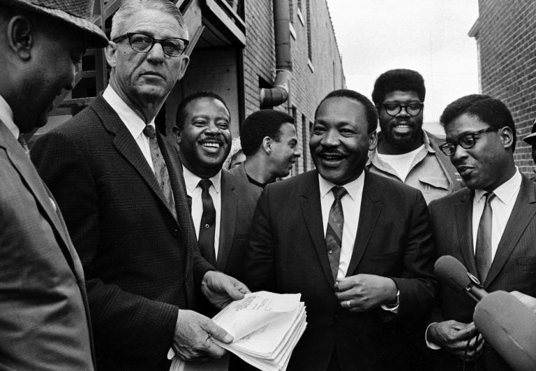 Dr. Martin Luther King Jr., center, and Rev. Ralph Abernathy, third from left, share a laugh outside  court in Decatur, Ga., Oct. 25, 1960. Others are unidentified. Andrew Young is seen at center, facing right. (AP Photo)