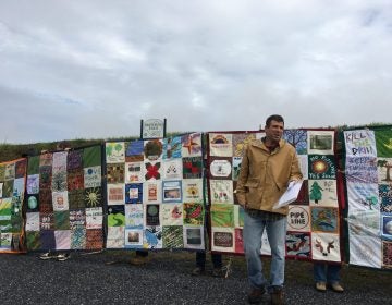 Mark Clatterbuck stands in front of a quilt designed to protest the Atlantic Sunrise pipeline. (Marie Cusick/StateImpact Pennsylvania)