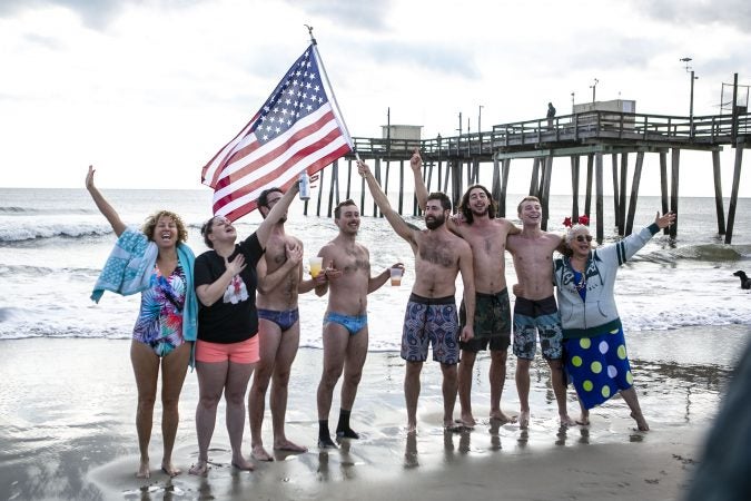 A group of the 2020 polar bear plungers in Margate, NJ sing before their jump in the ocean on Wednesday, January 1, 2020. (Miguel Martinez for WHYY)
