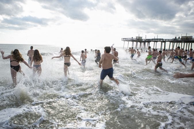 Participants of the 2020 polar bear plunge in Margate, NJ  run to the ocean on Wednesday, January 1, 2020. (Miguel Martinez for WHYY)