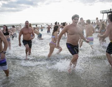 Participants of the 2020 polar bear plunge in Margate, NJ  run to the ocean on Wednesday, January 1, 2020. (Miguel Martinez for WHYY)