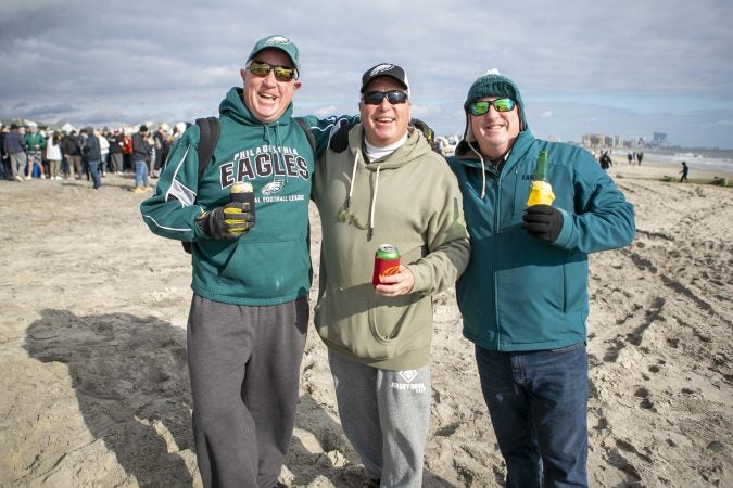 Brothers Brendan, Kevin, and Bill Bradley (from left) pose for a picture during the the 2020 polar bear plunge in Margate, NJ on Wednesday, January 1, 2020. (Miguel Martinez for WHYY)