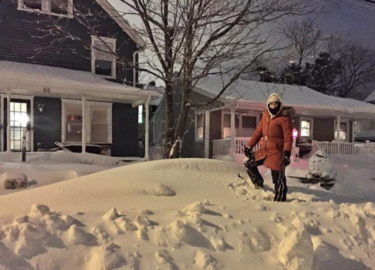 Caitrin Dunn stands on her  buried car in Monmouth County's Avon. (Photo courtesy of Jennifer Husar)