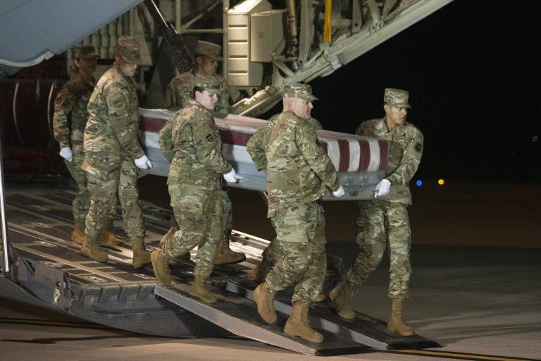 An Air Force team moves a transfer case containing the remains of one of the young sailors killed after a Saudi military student opened fire at a Pensacola naval base last month. (Cliff Owen/AP Photo)