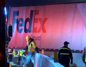 Workers in vests near a crashed FedEx truck after a fatal accident on the Pennsylvania Turnpike. (NBC Philadelphia)