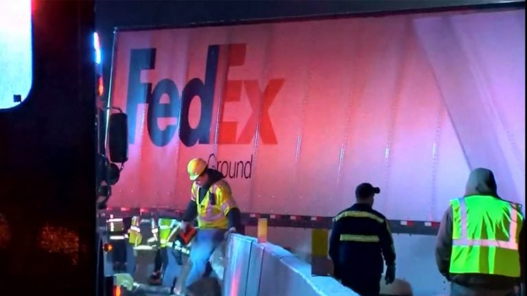 Workers in vests near a crashed FedEx truck after a fatal accident on the Pennsylvania Turnpike. (NBC Philadelphia)