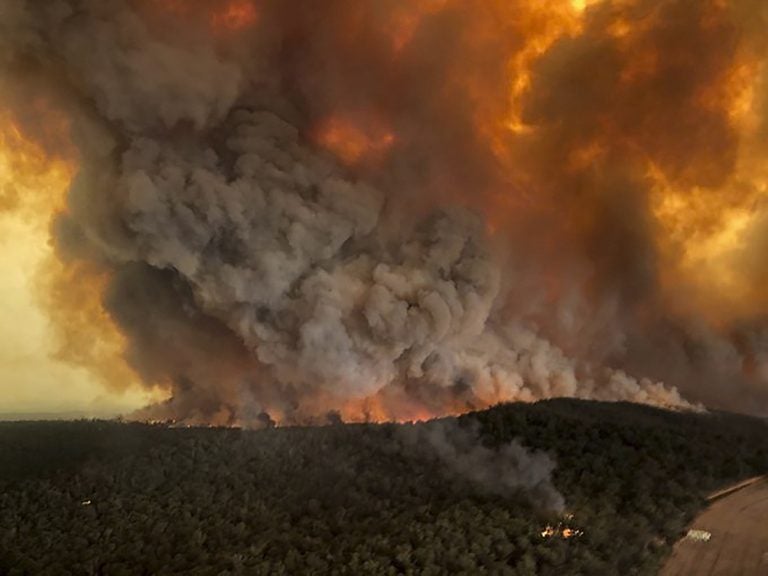 In this aerial photo Monday, Dec. 30, 2019, wildfires rage under plumes of smoke in Bairnsdale, Australia. (Glen Morey via AP, File)