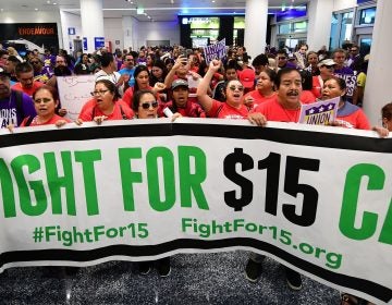 Airport employees, Uber and Lyft drivers, and other workers protest for a $15 minimum wage at Los Angeles International Airport in October. Increases in minimum wages contributed to bigger pay gains for lower-income workers. (Frederic J. Brown/AFP via Getty Images)