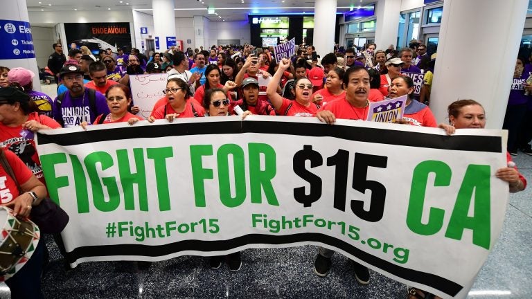 Airport employees, Uber and Lyft drivers, and other workers protest for a $15 minimum wage at Los Angeles International Airport in October. Increases in minimum wages contributed to bigger pay gains for lower-income workers. Airport employees, Uber and Lyft drivers, and other workers protest for a $15 minimum wage at Los Angeles International Airport in October. Increases in minimum wages contributed to bigger pay gains for lower-income workers. (Frederic J. Brown/AFP via Getty Images)