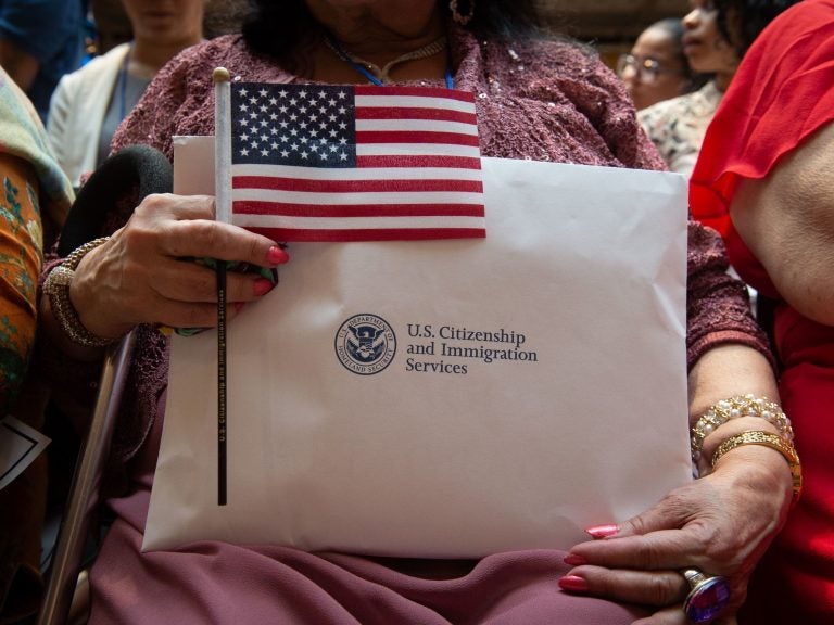 A newly sworn-in U.S. citizen holds the U.S. flag and paperwork during a 2018 naturalization ceremony in New York City. (Bryan R. Smith/AFP via Getty Images)