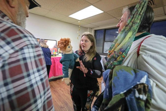 Lora Divorski (center) speaks with attendees about her work during an art therapy exhibit on Feb. 10, 2020, at The Art Studio in Wilmington, Del. (Saquan Stimpson for WHYY)