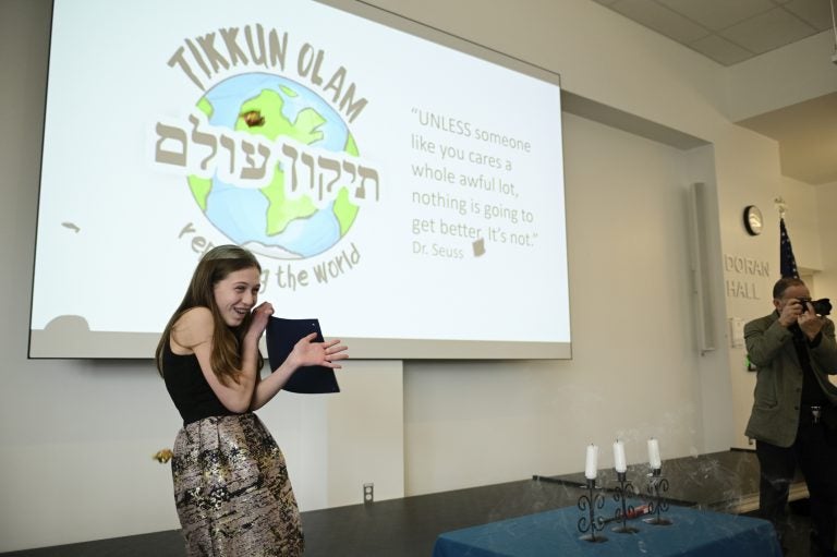 Sophie Mills braces for candy throws during her bat mitzvah ceremony at Jewish Children's Folkshul in Philadelphia. Family and friends gathered to see the seventh-grader give a presentation on five inspirational women who repaired the world. (Bastiaan Slabbers for WHYY)