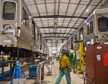 Two Market-Frankford Line cars lifted for repairs at the 69th Street SEPTA repair shop. (Kimberly Paynter/WHYY)