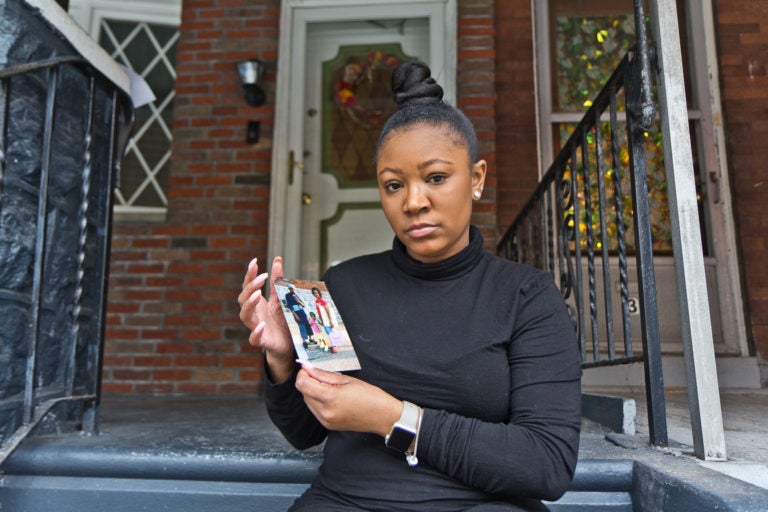 Sakeenah Benjamin holds a photo of her cousin Manny, who was shot and killed in her West Philly neighborhood when she was 10 years old. (Kimberly Paynter/WHYY)