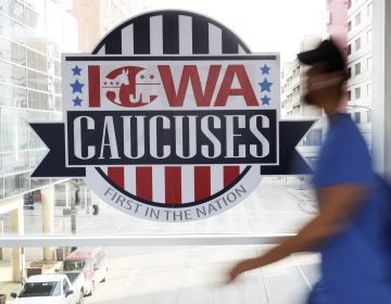A pedestrian walks past a sign for the Iowa Caucuses on a downtown skywalk, Tuesday, Feb. 4, 2020, in Des Moines, Iowa. (Charlie Neibergall/AP Photo)