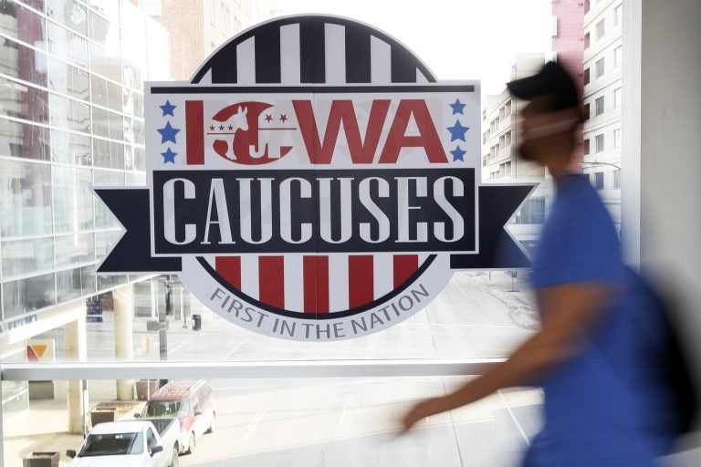 A pedestrian walks past a sign for the Iowa Caucuses on a downtown skywalk, Tuesday, Feb. 4, 2020, in Des Moines, Iowa. (Charlie Neibergall/AP Photo)