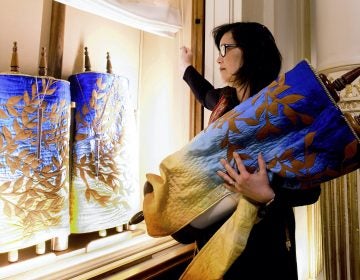 In this Saturday, Feb. 1, 2020, photo, Rabbi Jacqueline Mates-Muchin removes a Torah scroll from the ark, a cabinet that houses scrolls of the Hebrew Bible, while preparing for Shabbat morning service at Temple Sinai in Oakland, Calif. (Noah Berger/AP Photo)