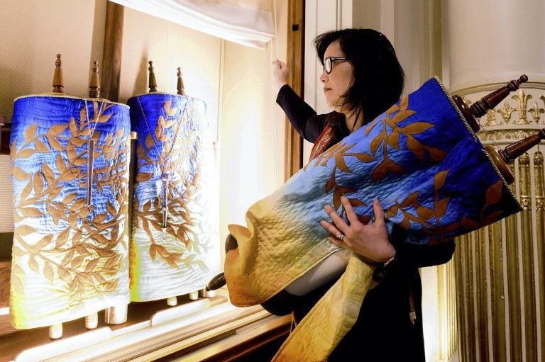 In this Saturday, Feb. 1, 2020, photo, Rabbi Jacqueline Mates-Muchin removes a Torah scroll from the ark, a cabinet that houses scrolls of the Hebrew Bible, while preparing for Shabbat morning service at Temple Sinai in Oakland, Calif. (Noah Berger/AP Photo)