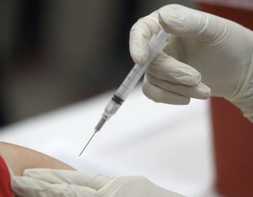 A syringe with an influenza vaccine inside heads to its mark during a flu vaccination at Eastfield College in Mesquite, Texas, Thursday, Jan. 23, 2020. (LM Otero/AP Photo)