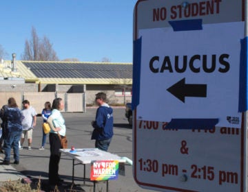 Volunteers for various campaigns talk to voters as they enter a presidential caucus site at Mendive Middle School in Sparks, Nevada on Saturday, Feb. 22, 2020. (Scott Sonner/AP Photo)
