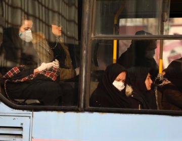 Woman, wearing face masks, travel on a public bus in a street in western Tehran, Iran, Saturday, Feb. 29, 2020. (Vahid Salemi/AP Photo)