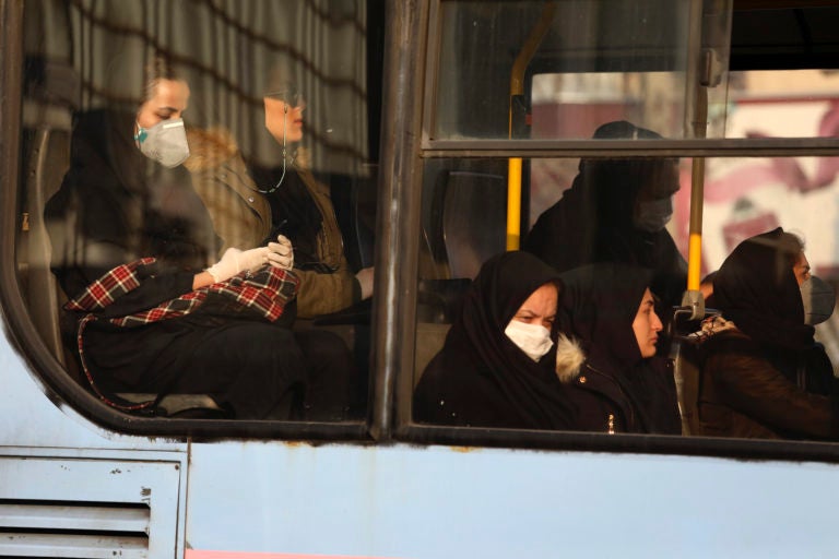 Woman, wearing face masks, travel on a public bus in a street in western Tehran, Iran, Saturday, Feb. 29, 2020. (Vahid Salemi/AP Photo)