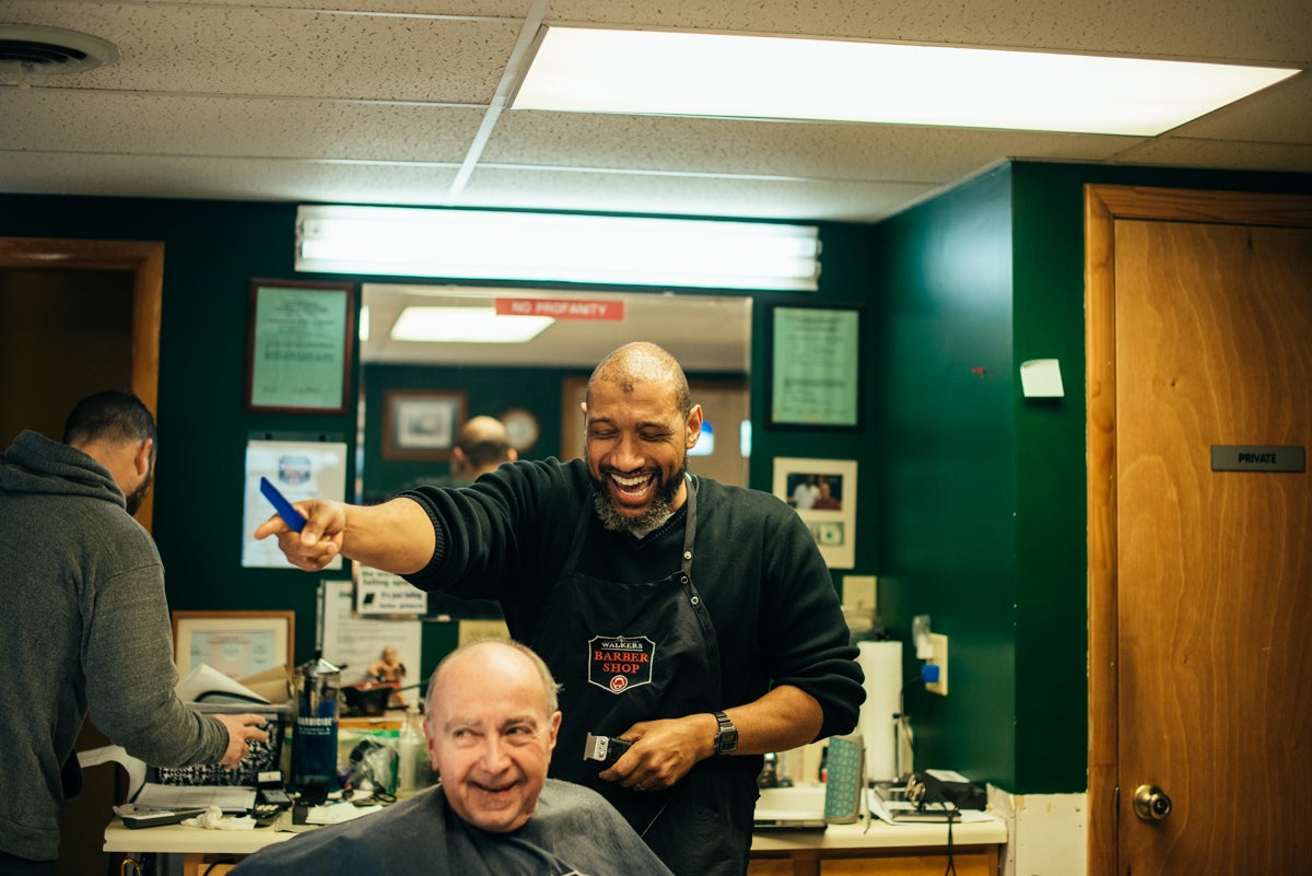 Lance Walker laughs while giving customer Tom Buckus a haircut. (Dani Fresh for Keystone Crossroads)