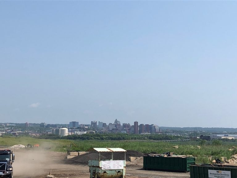 The skyline of Wilmington looms in the background of the Waste Management Inc. landfill south of the city. (Cris Barrish/WHYY)