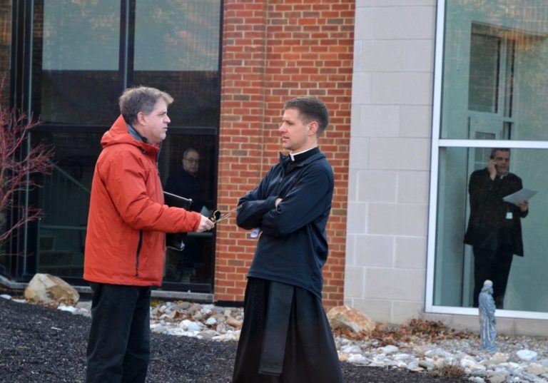 At left, the Rev. Matthew Larlick of St. Joseph’s in Berwick, Columbia County, speaks with another priest outside the Harrisburg diocese office after a meeting Wed., Feb. 19, 2020. (Brett Sholtis/WITF)