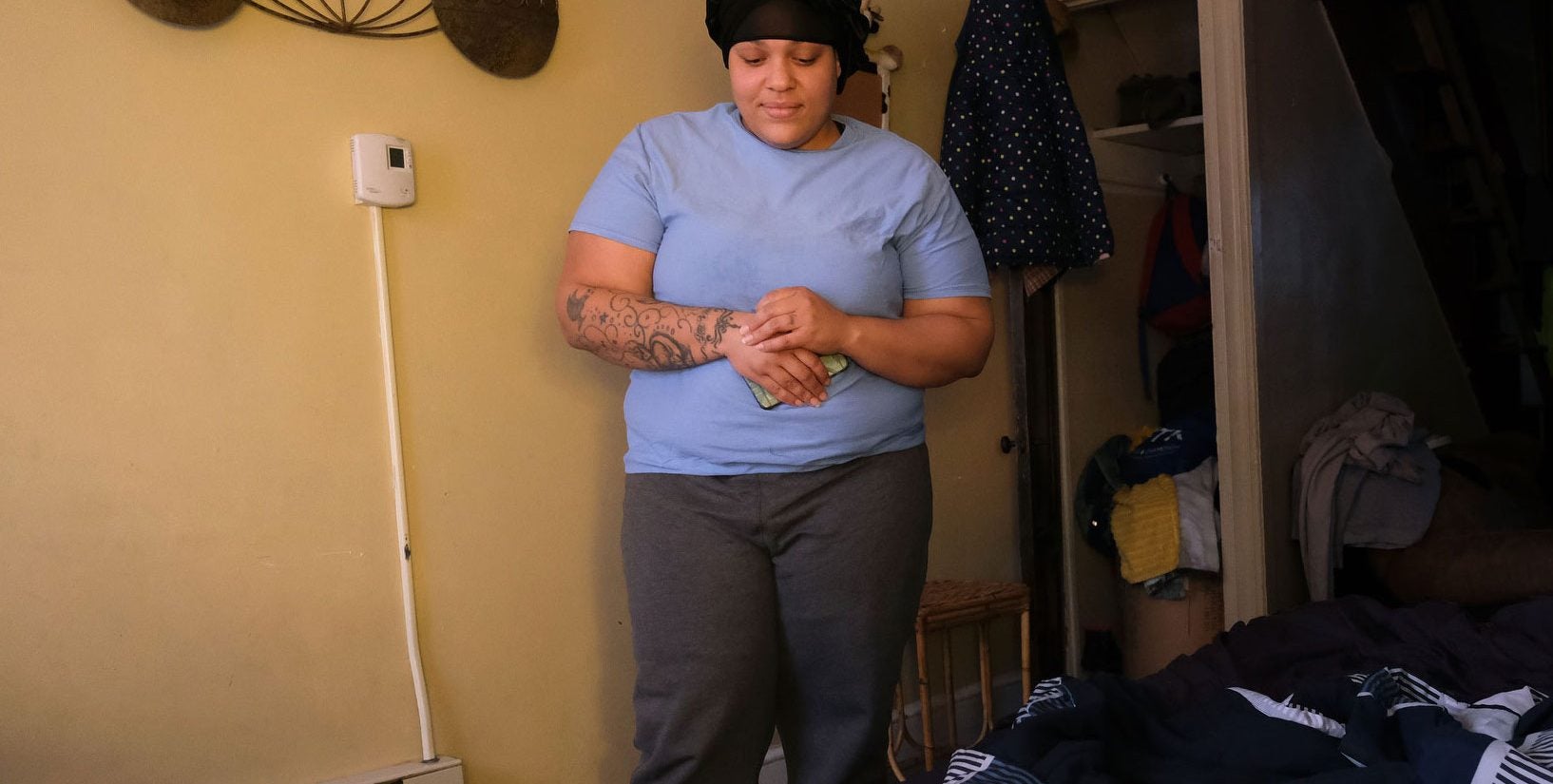 Javonna Lee looks down at her two toddlers on the air mattress where they've been sleeping in her sister's apartment. (Matt Smith for Keystone Crossroads)